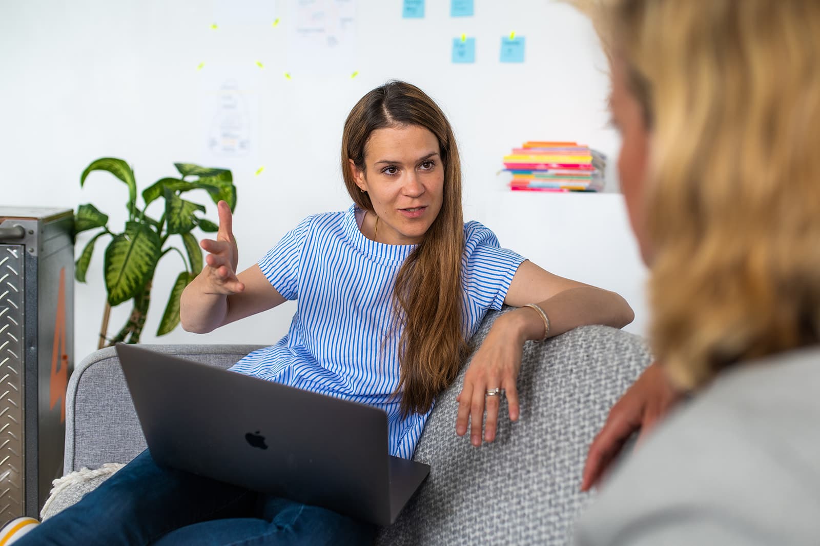 Frau im Gespräch, diskutiert am Laptop im Wohnzimmer.