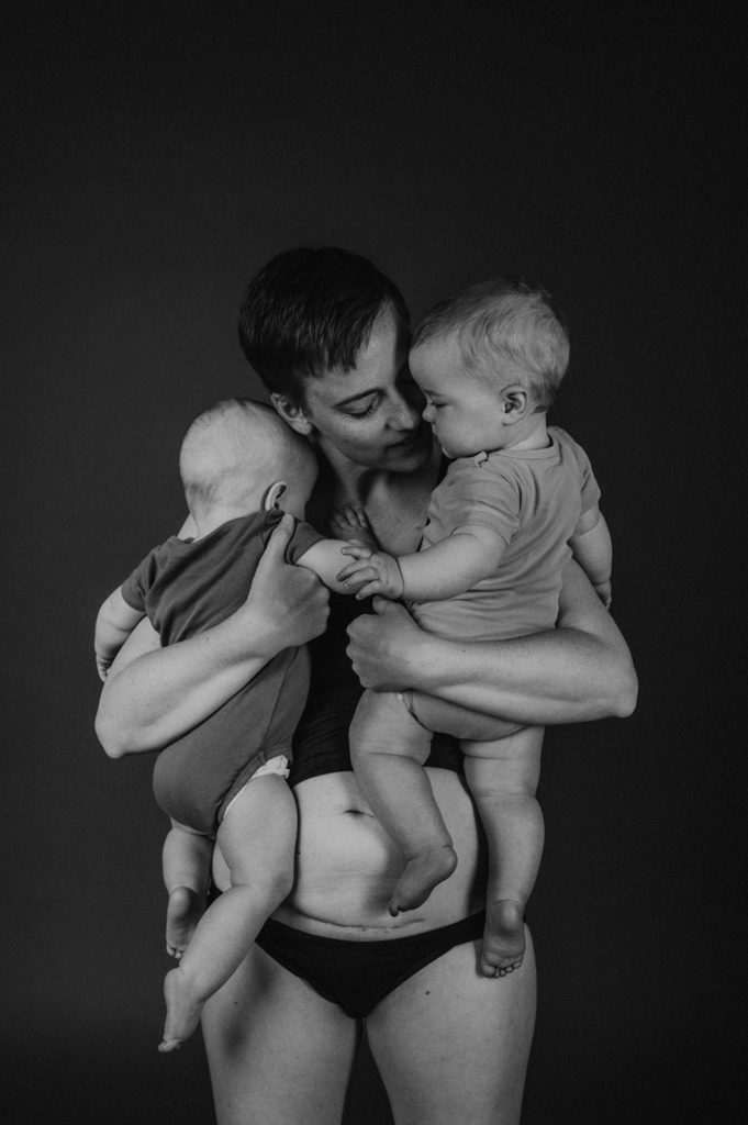 Portrait Frau mit Zwillingen auf dem Arm und Kaiserschnittnarbe