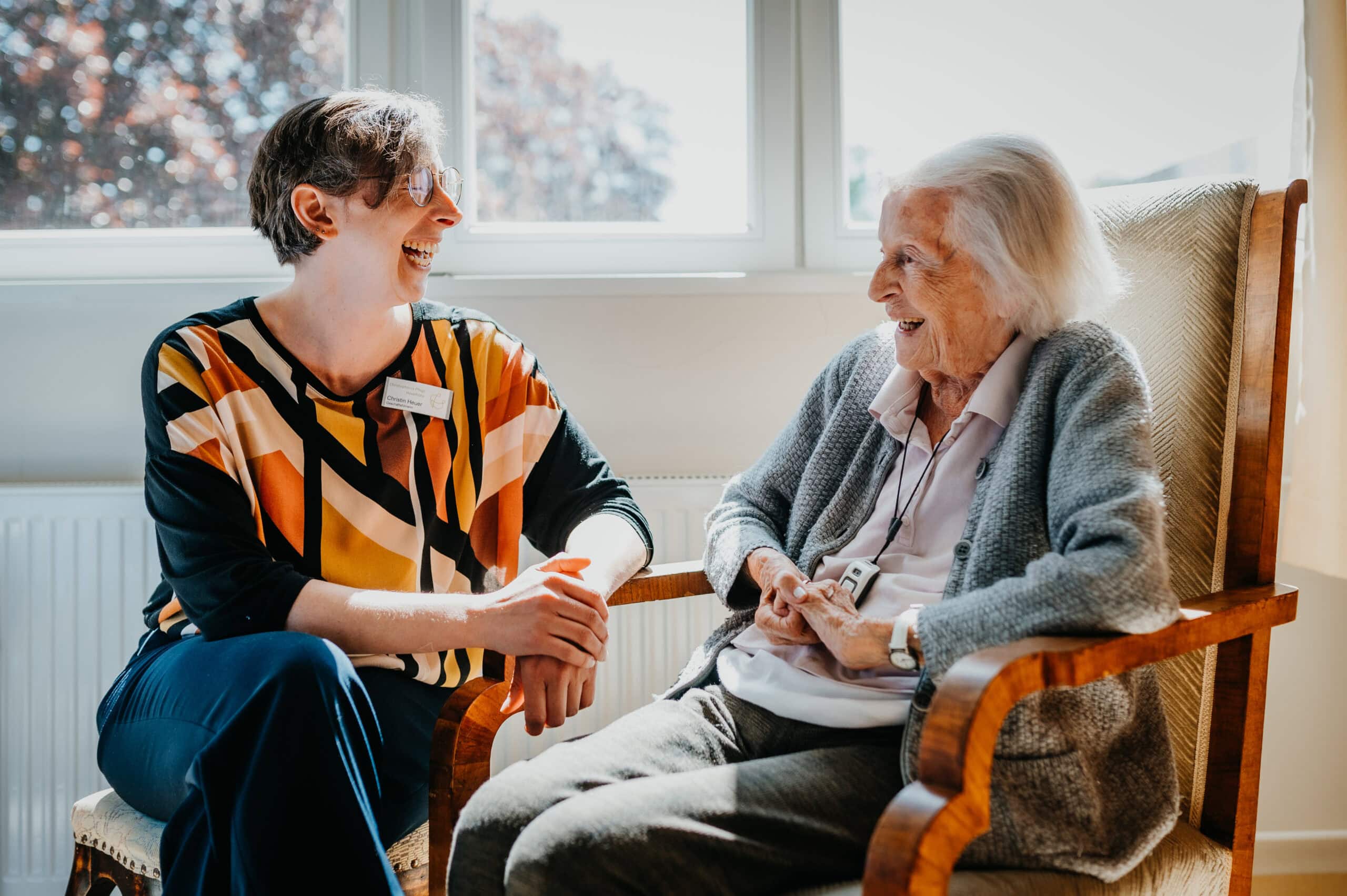 personal-branding-fotografie-seniorenheim-authentisch.jpg Personal Branding Fotografie im Christopherus Pflege Havelhöhe Seniorenheim - Pflegerin und Seniorin im Gespräch, lachende Alltagsszene
