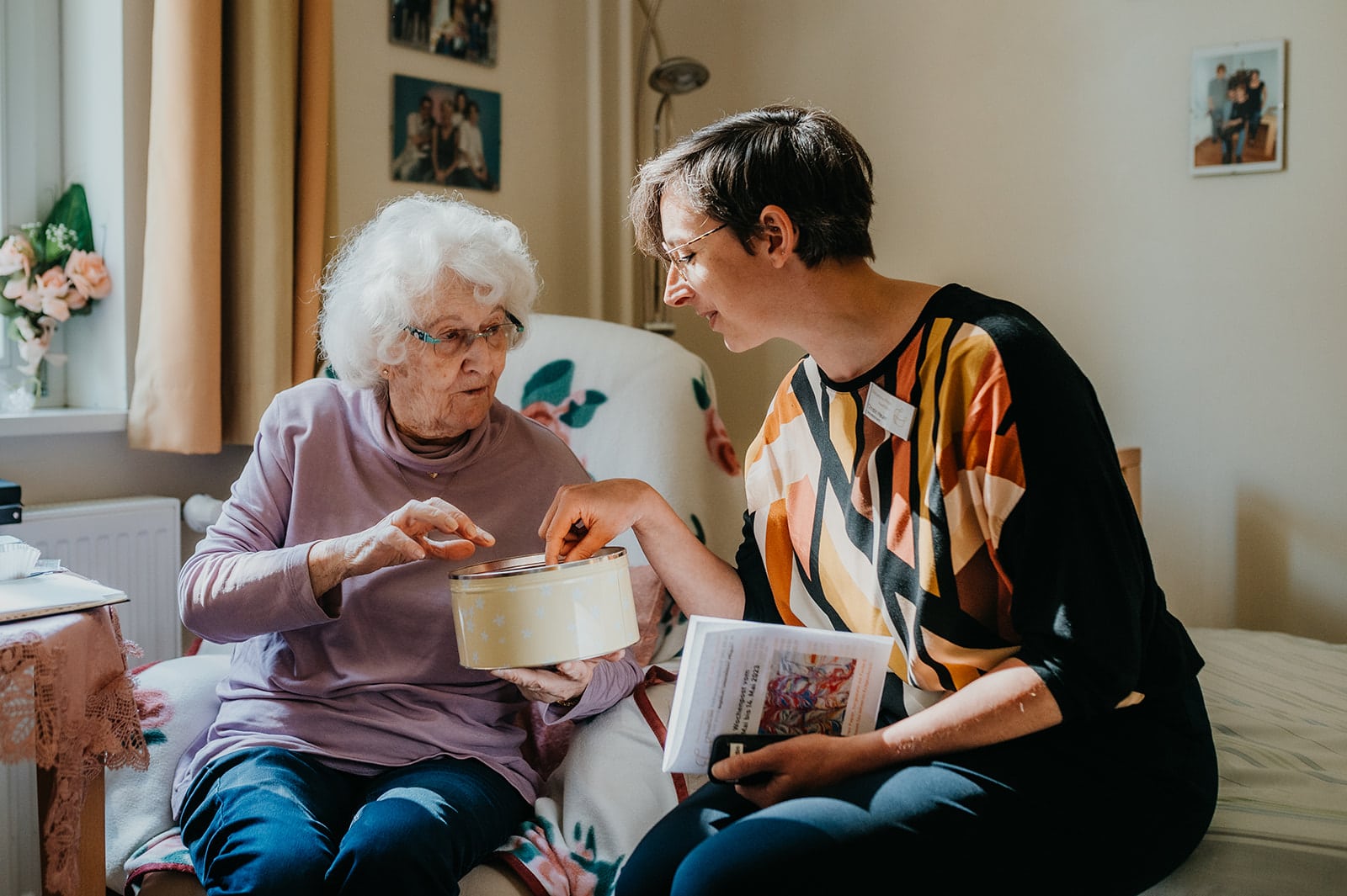 Personal Branding Fotografie im Christophorus Pflege Havelhöhe Seniorenheim – Pflegerin im Gespräch mit Seniorin bei gemeinsamer Beschäftigung