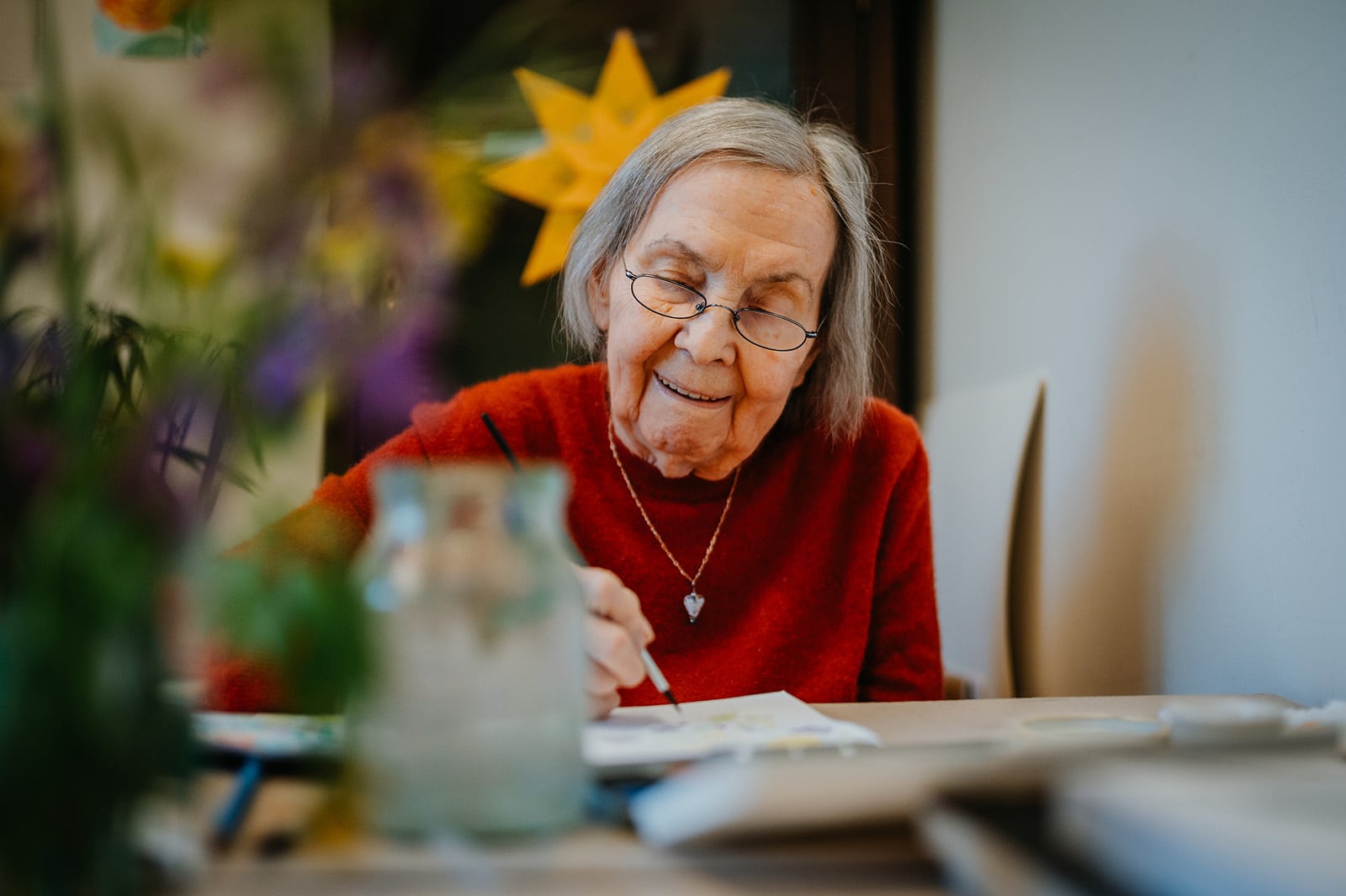 Personal Branding Fotografie im Christophorus Pflege Havelhöhe Seniorenheim – Seniorin malt lächelnd am Tisch, kreative Content Fotografie