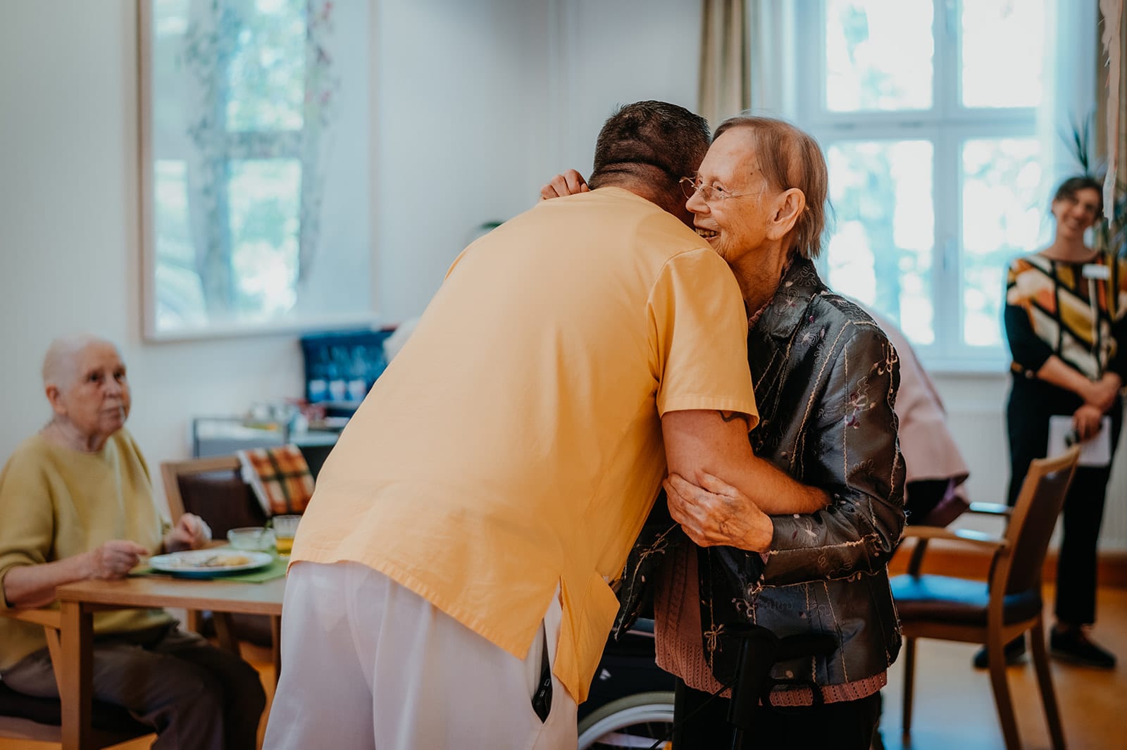 Personal Branding Fotografie im Christophorus Pflege Havelhöhe Seniorenheim – Seniorin umarmt Pfleger, Symbol für Nähe und Vertrauen