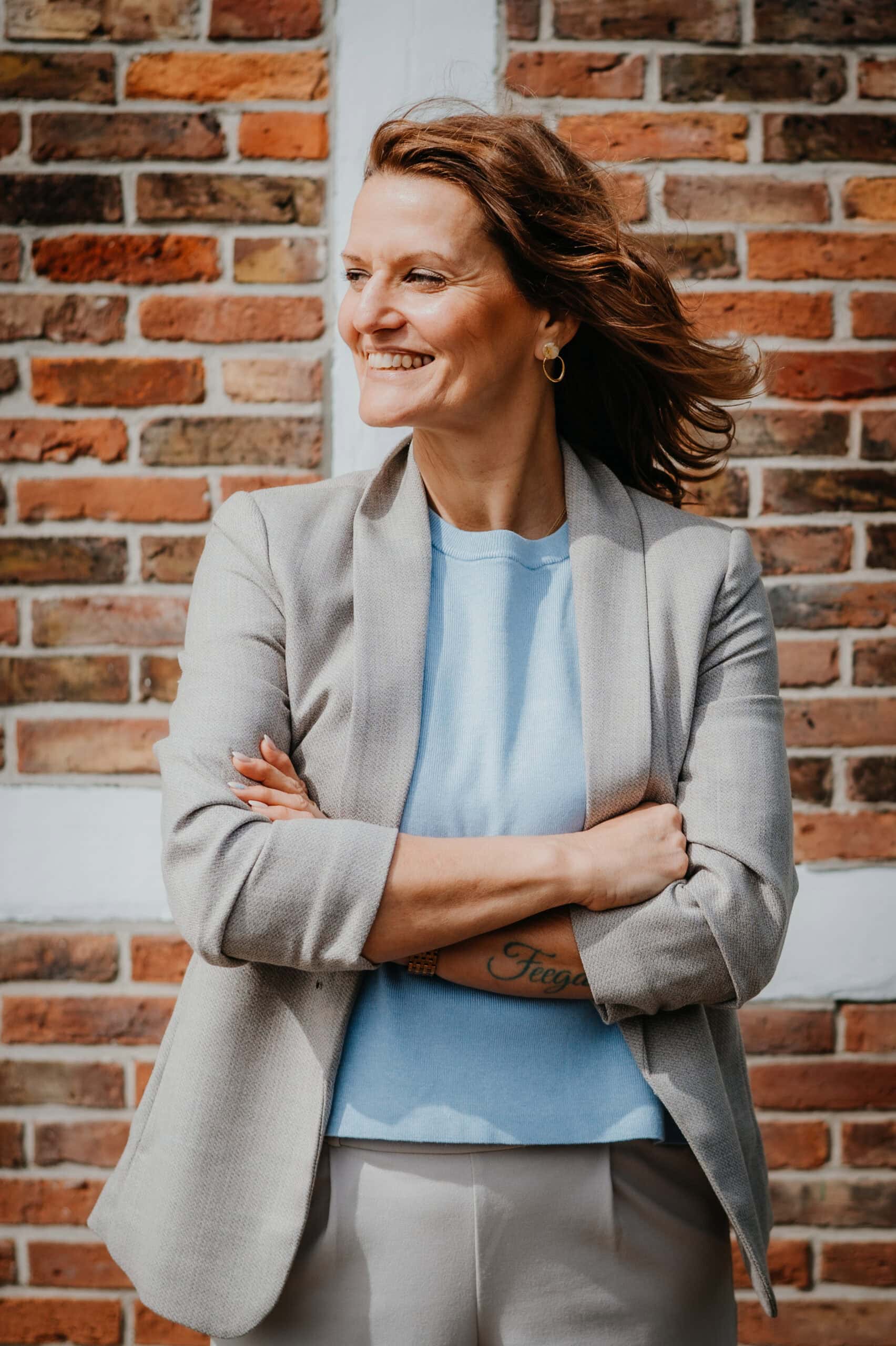 a woman smiling with arms crossed