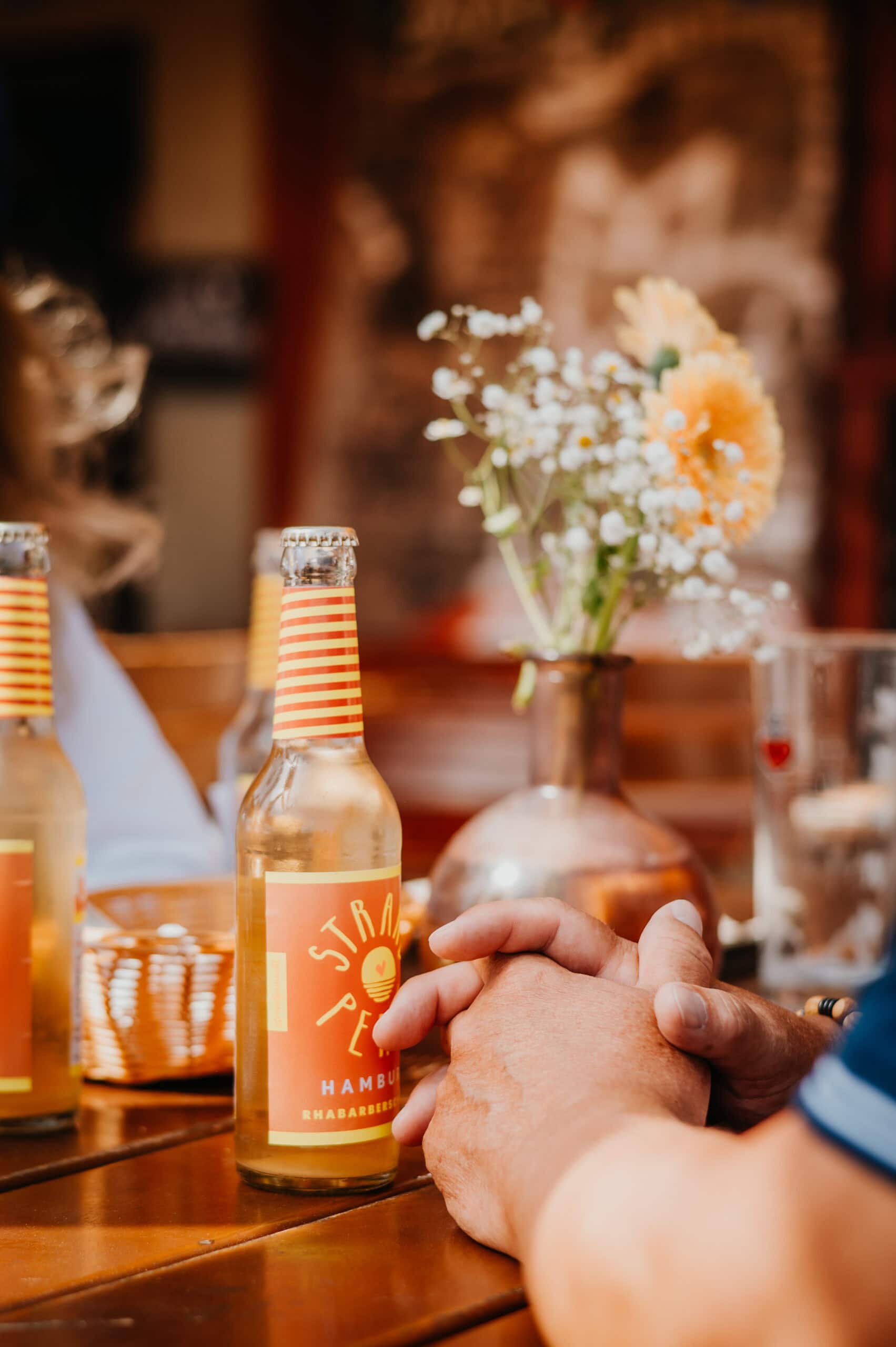 leev GmbH Emotionale Businessreportage 3 Eine Frau und ein Mann stoßen in einer Strandbar mit Apfelsaft an