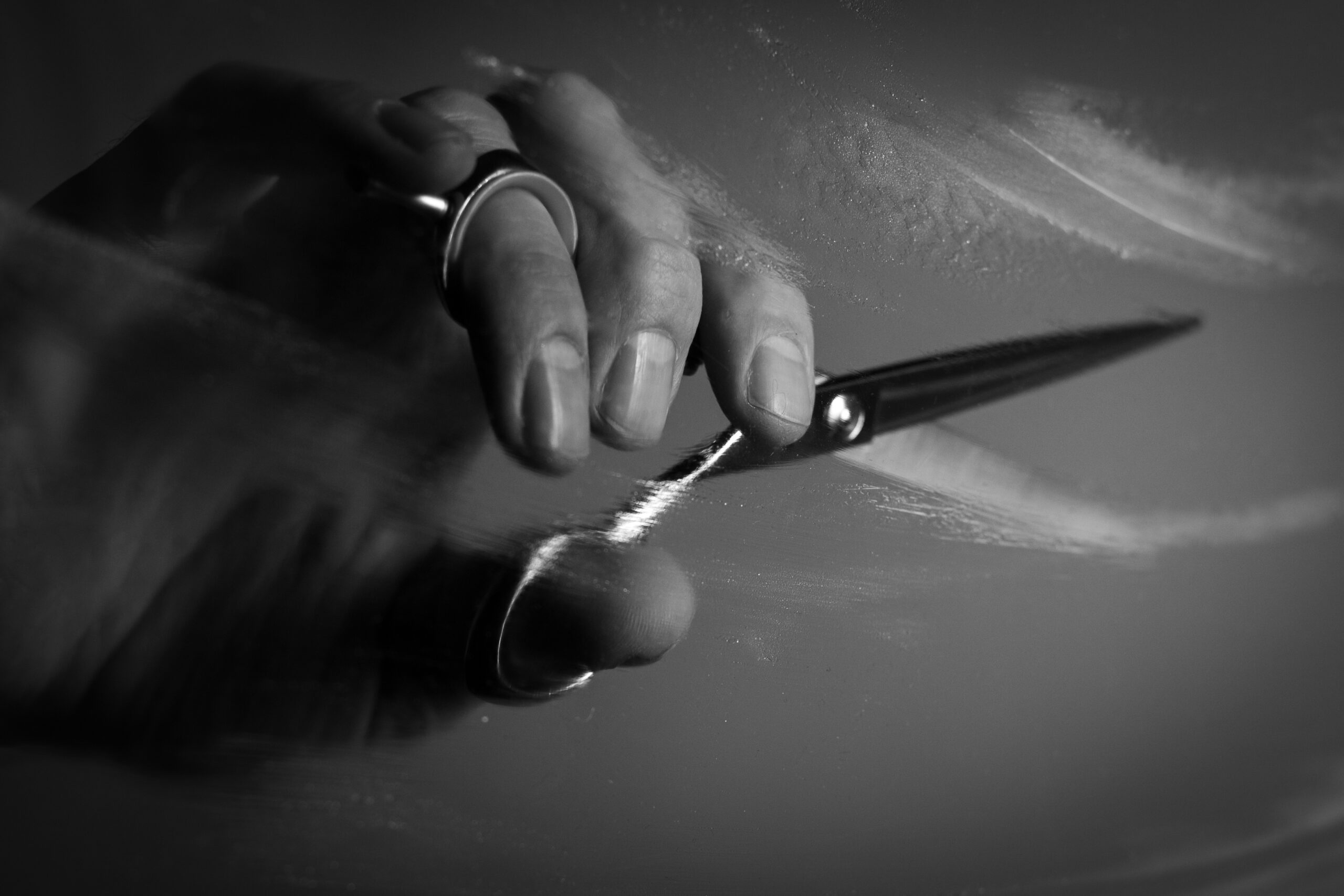 Künstlerische Hand hält Stift, kreative Porträtaufnahme in Schwarz-Weiß.