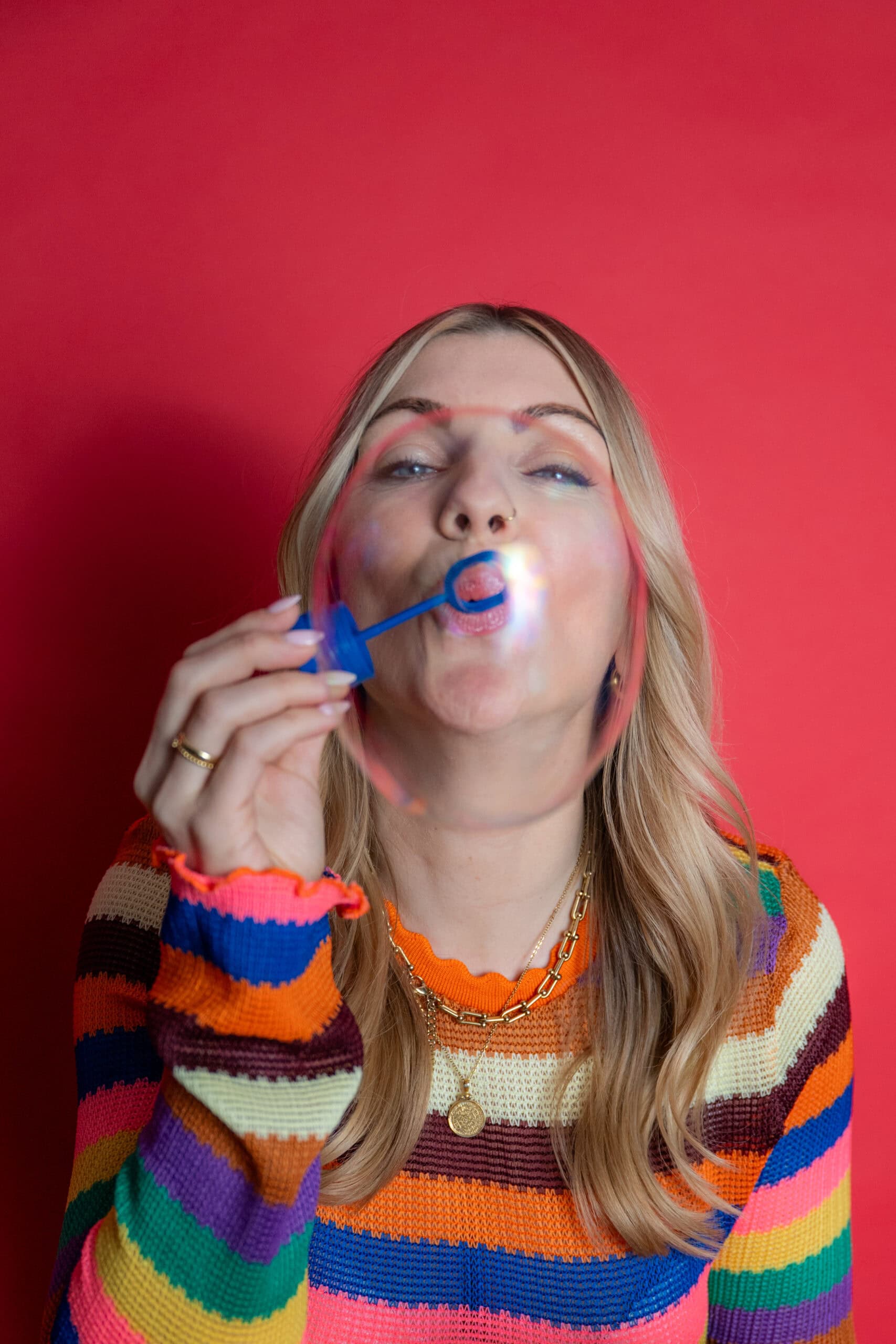 Bunte Frau bläst Seifenblase, Spaß und Freude, farbenfrohes Portrait.