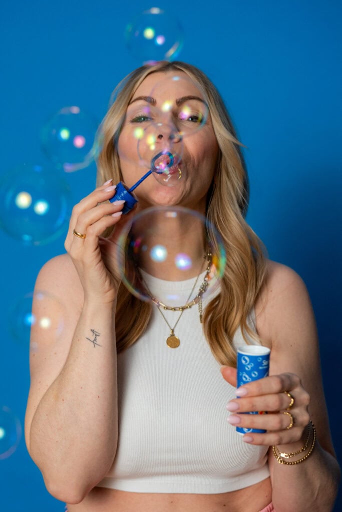 Frau bläst Seifenblasen, kreative und verspielte Atmosphäre, Nahaufnahme, bunte Blasen, Spaß und Fre.