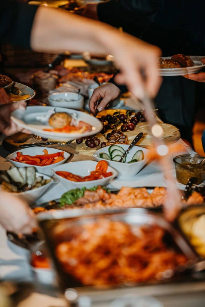 Festliches Buffet mit vielfältigen Speisen, Obst und Desserts bei einer Feier.