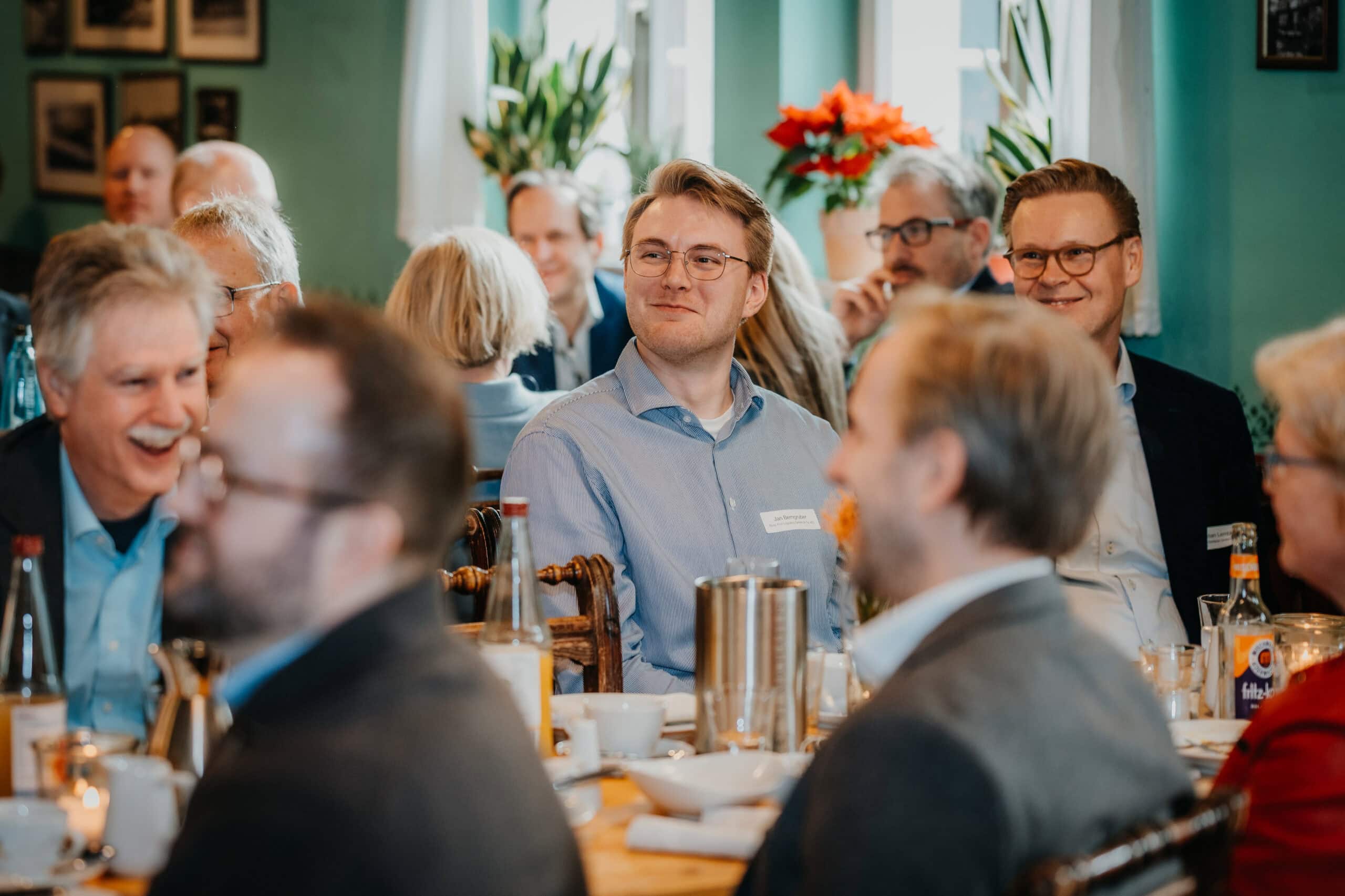 Teammeeting in Restaurant, Geschäftsleute diskutieren und lachen.