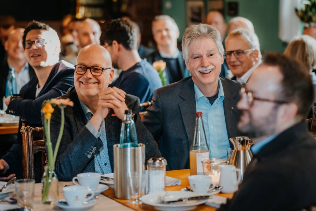 Fröhliche Menschen bei einem Treffen, lachen und genießen die Gesellschaft.