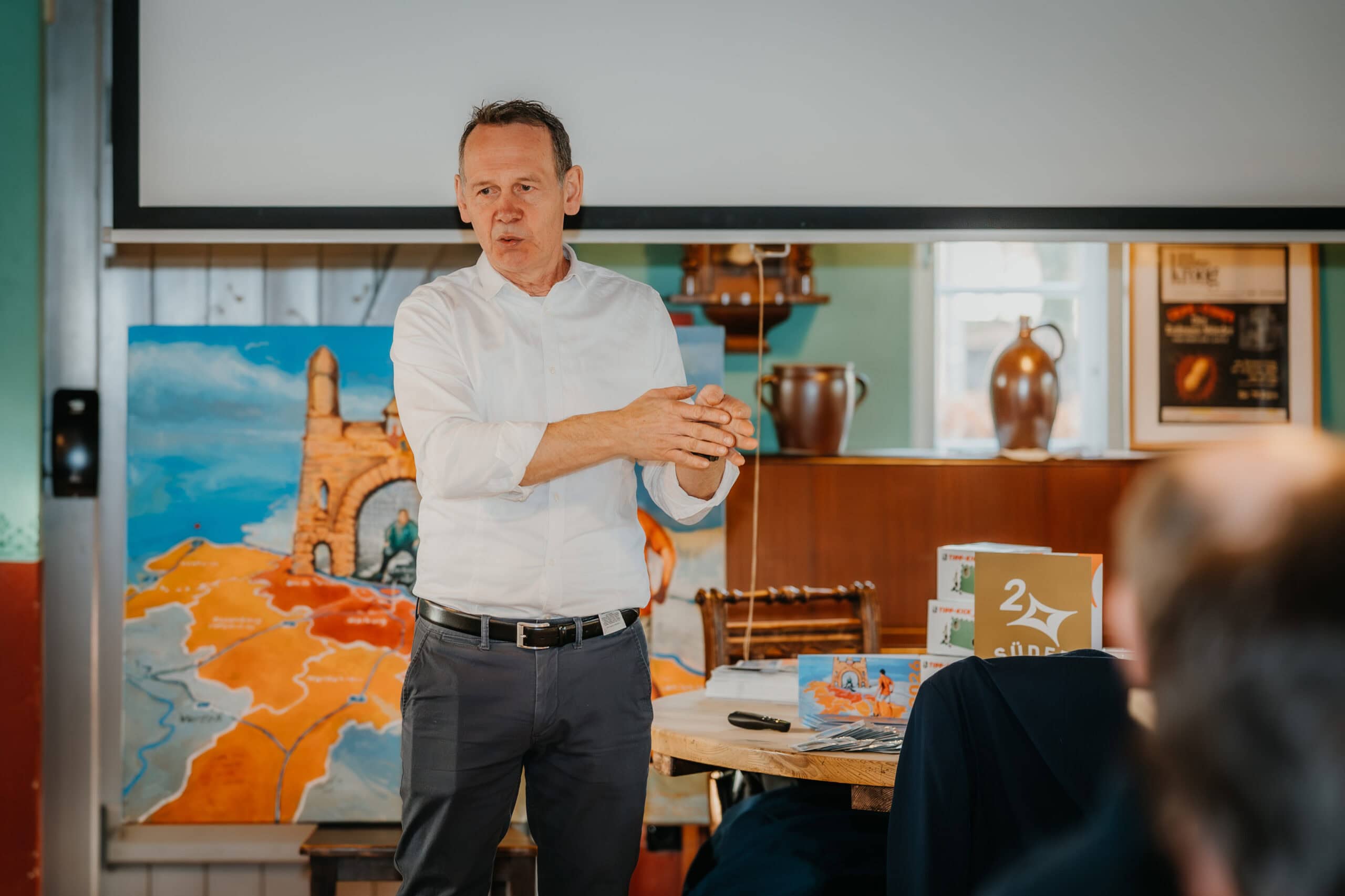 Reiseleiter erklärt Tourismus in Deutschland während einer Präsentation im Seminarraum.