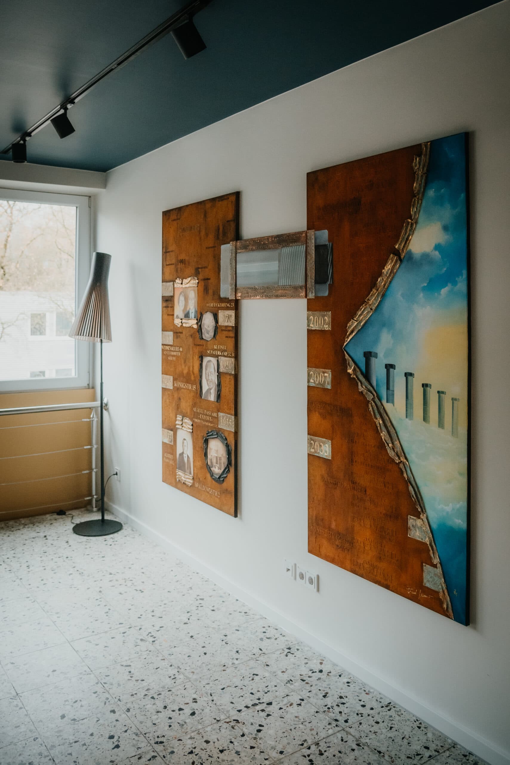 Kunstwerke an der Wand: Abstrakte Gemälde und Mixed-Media-Kunst in einem stilvollen Raum.