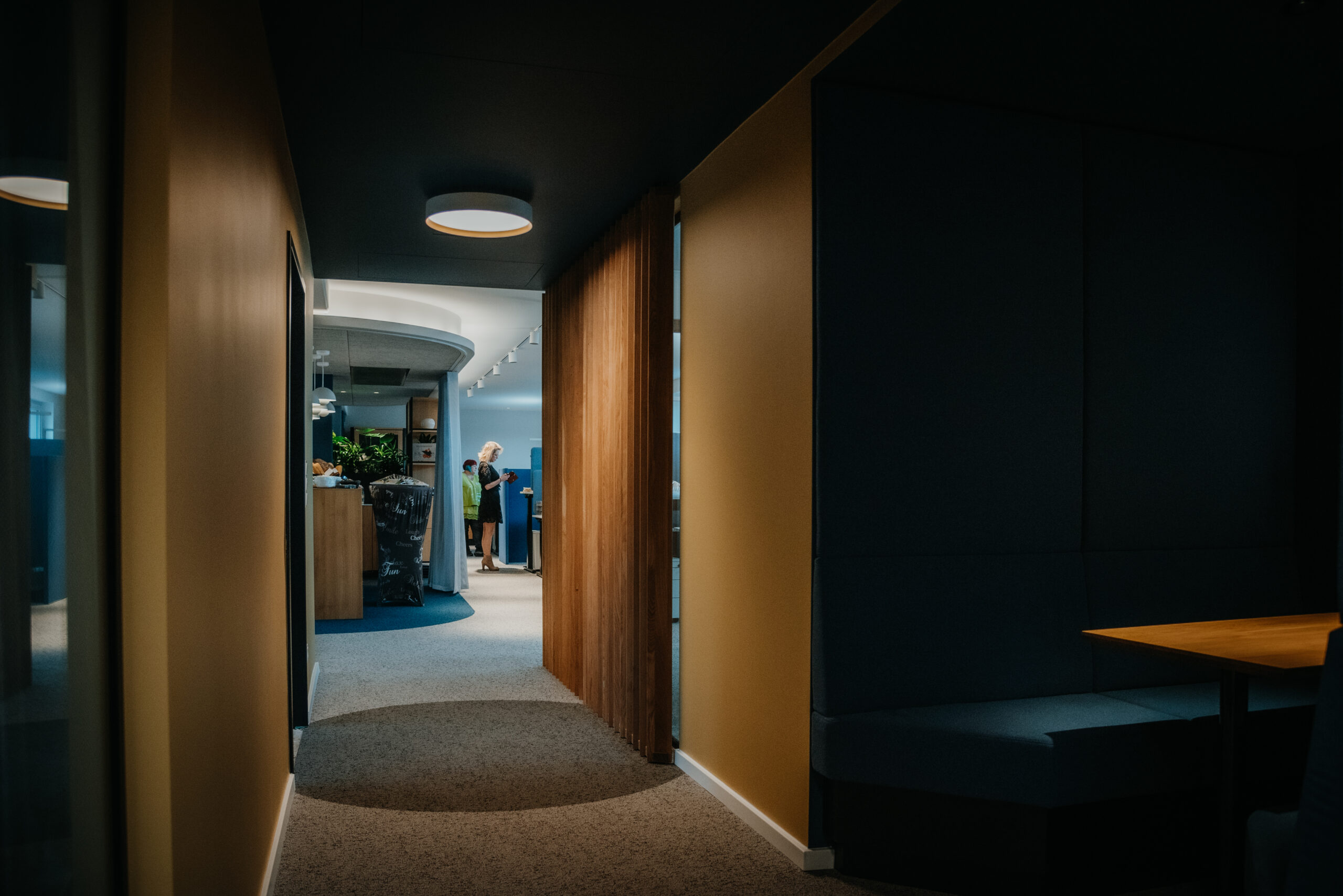 Modernes Büro mit Sitzbereich und Mitarbeitern im Flur.