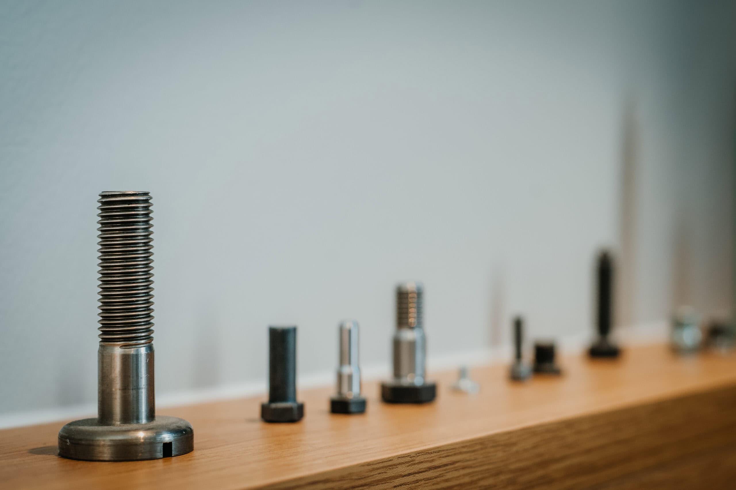 Verschiedene Metallhülsen und Werkzeuge auf einem Holzregal.