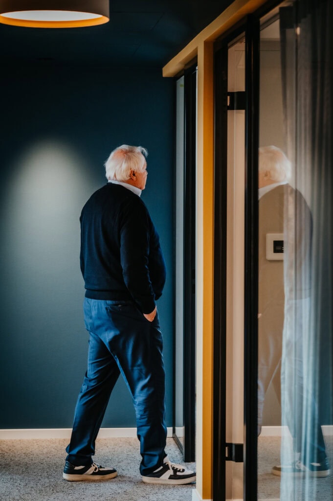 Älterer Mann schaut in den Spiegel, reflektiert im stilvollen Raum, Fokus auf Selbstwahrnehmung und.