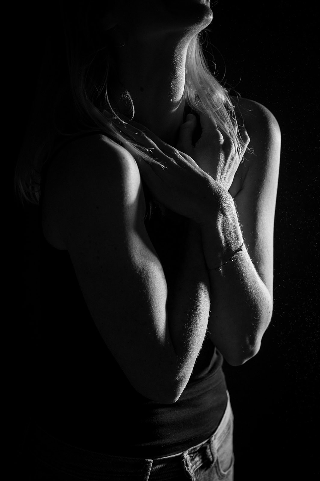 Künstlerische Schwarz-Weiß-Fotografie einer Frau, Fokus auf Licht und Schatten.